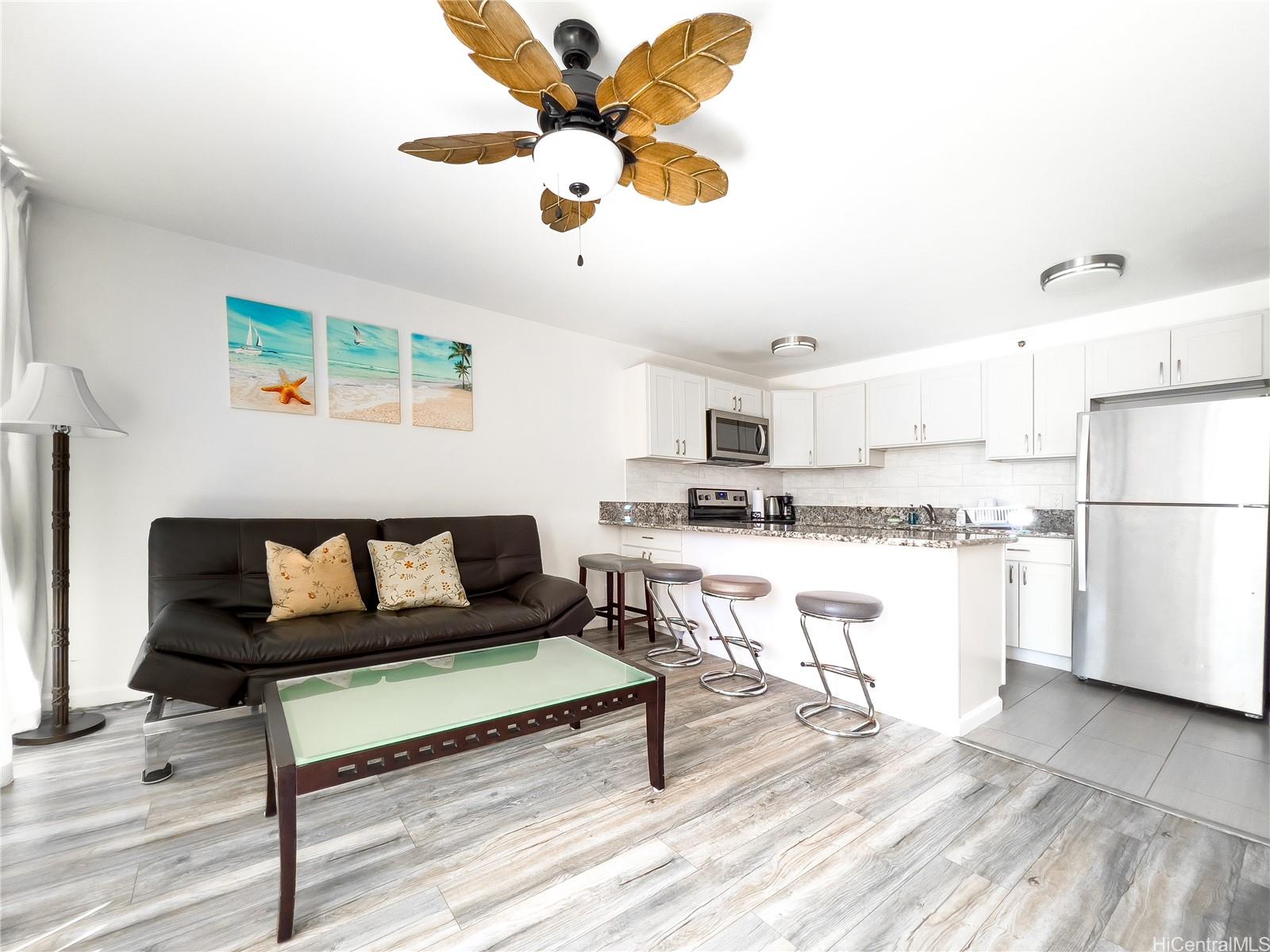 a living room with kitchen island furniture and a kitchen view