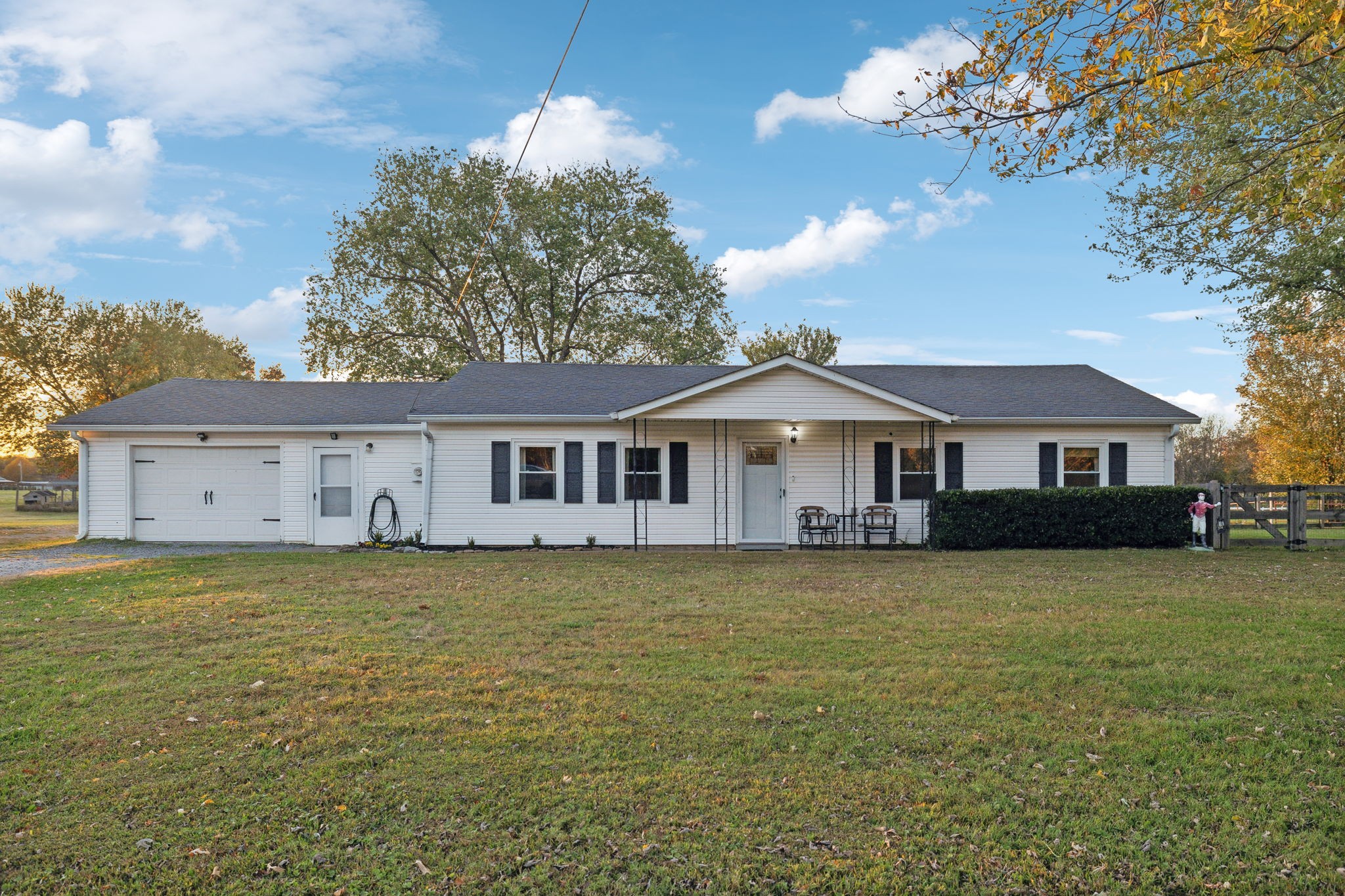 a front of a house with a garden and trees