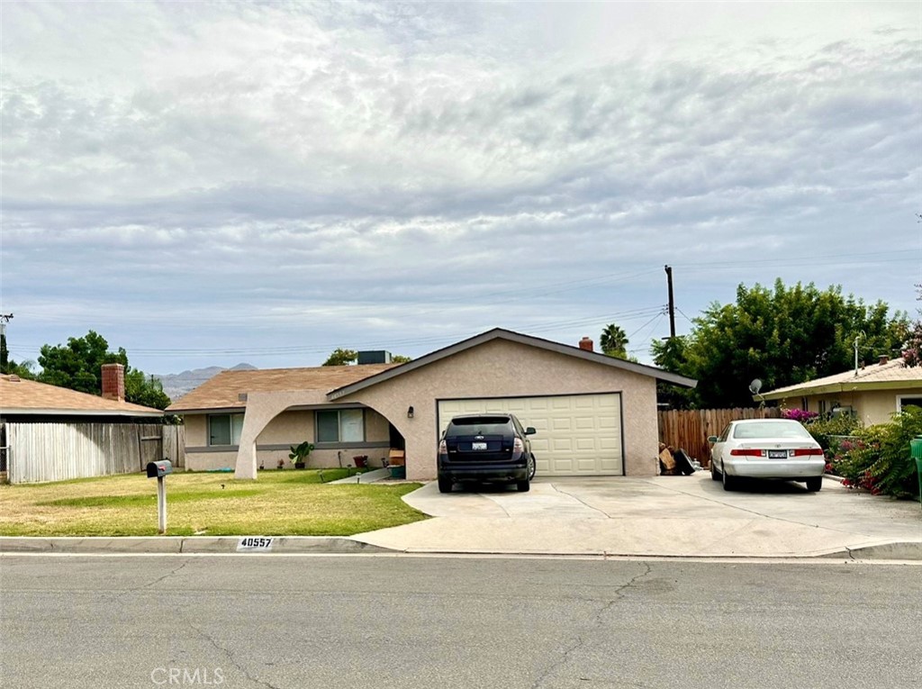 a front view of a house with a garden and parking