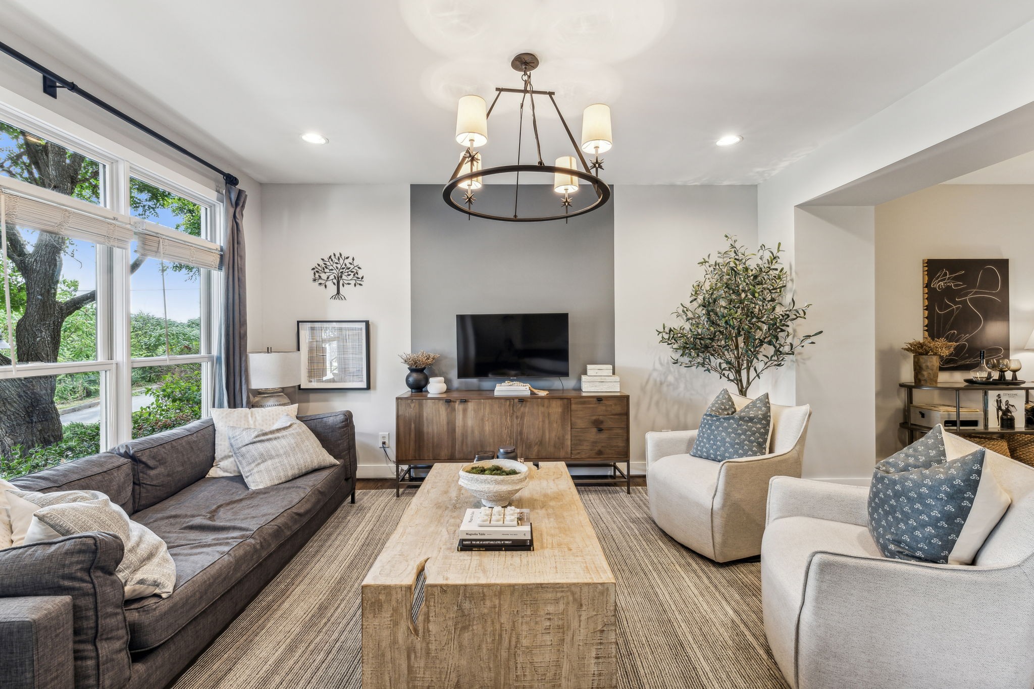 a living room with furniture a flat screen tv and a large window