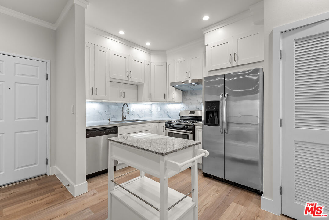 a kitchen with a refrigerator a sink and cabinets