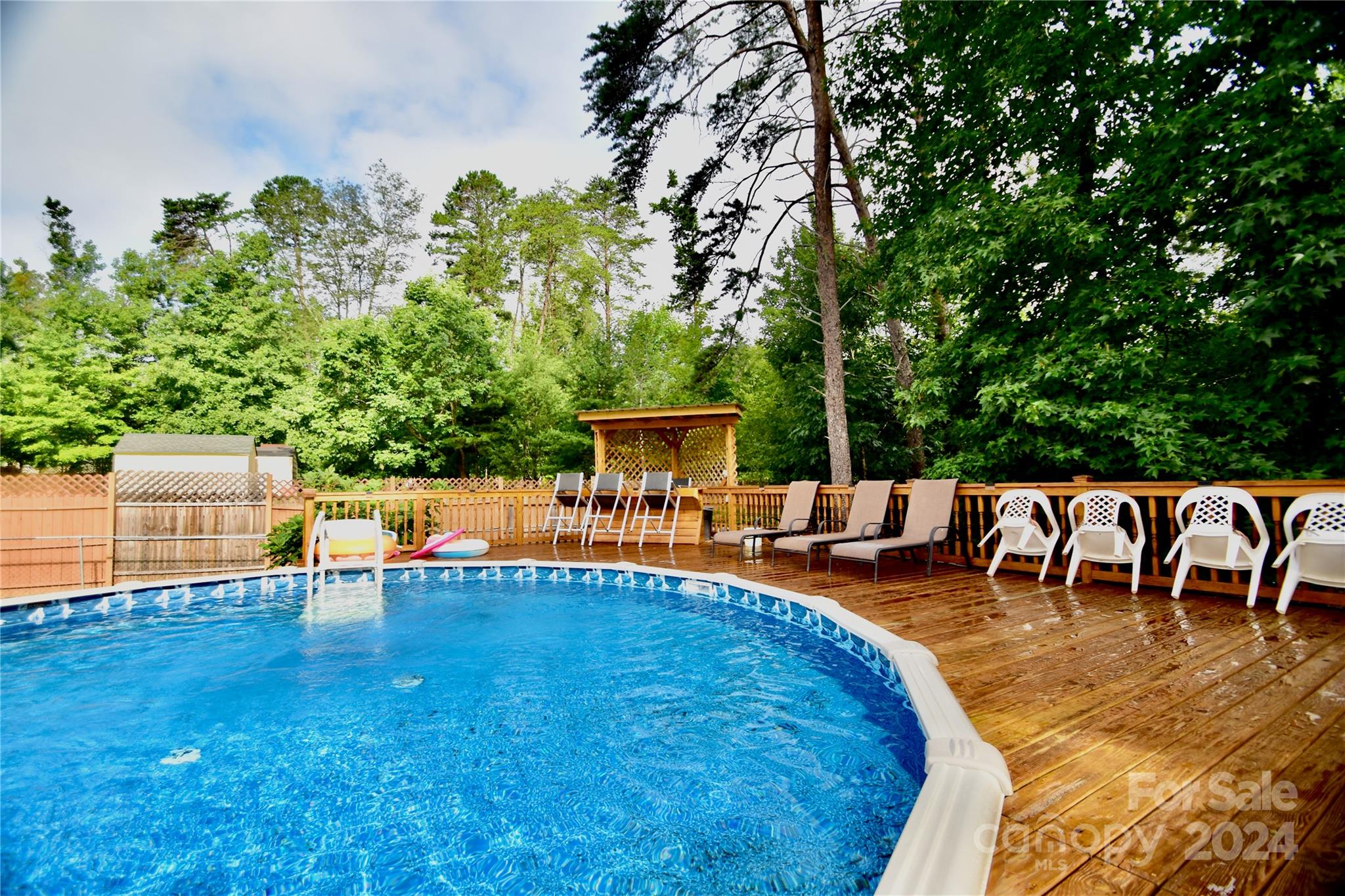 swimming pool view with sitting space and garden