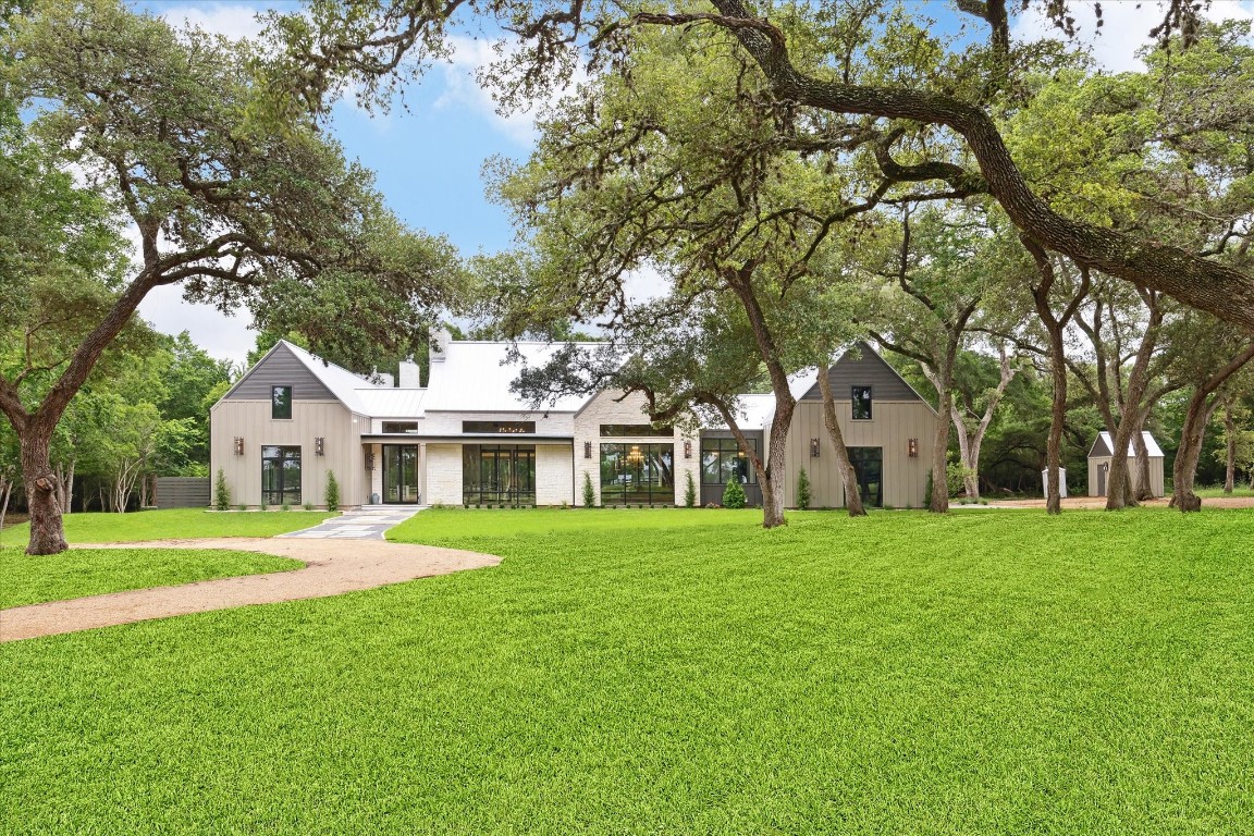 a front view of a house with a garden and trees