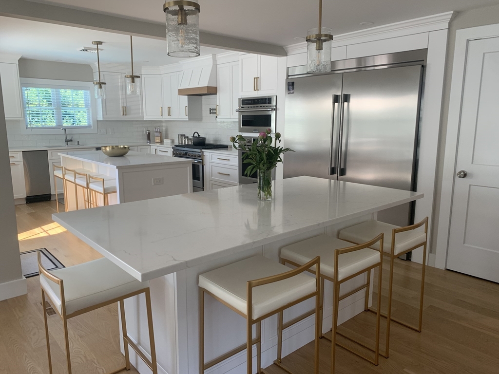 a kitchen with stainless steel appliances granite countertop a sink a stove and a refrigerator