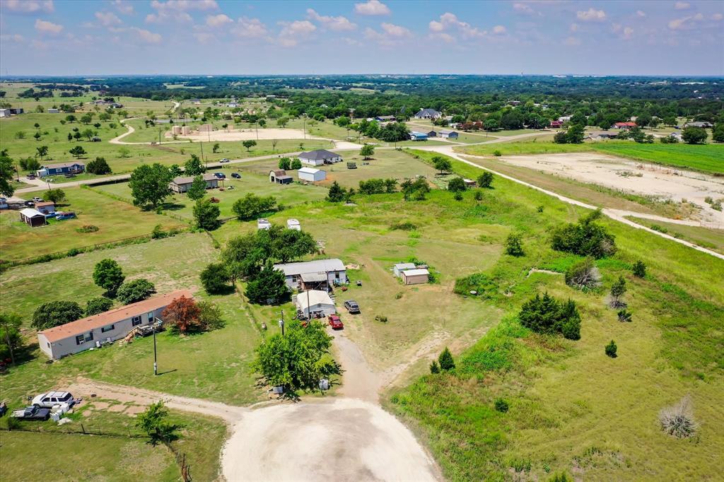 an aerial view of residential houses with outdoor space and trees