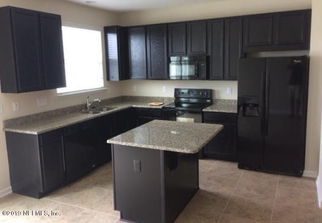 a kitchen with a sink a microwave a refrigerator and cabinets