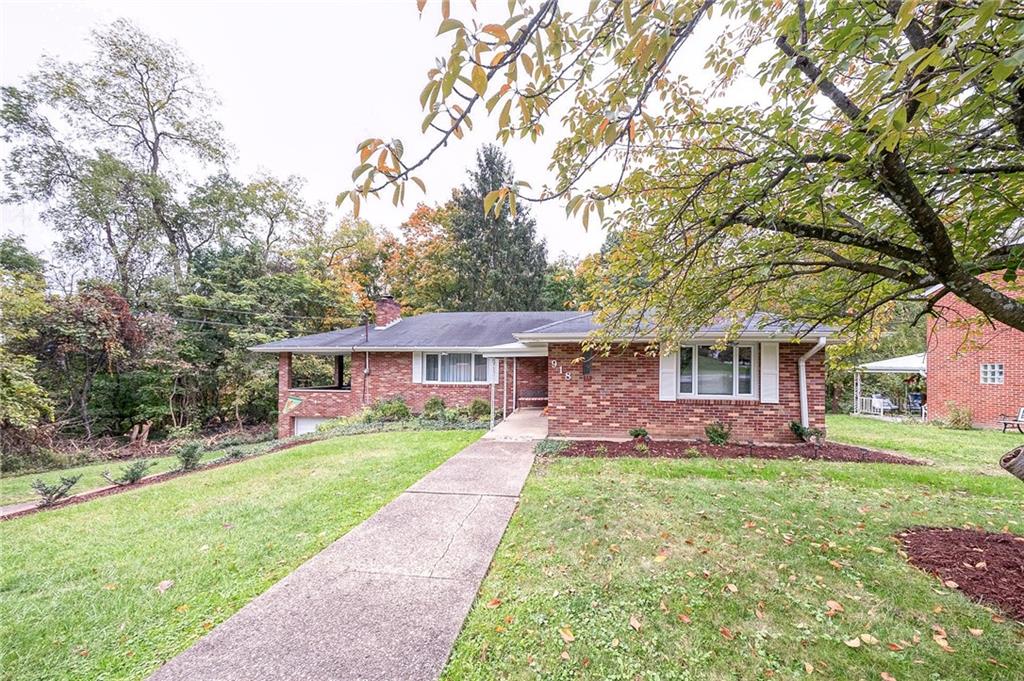 a front view of a house with a yard and trees