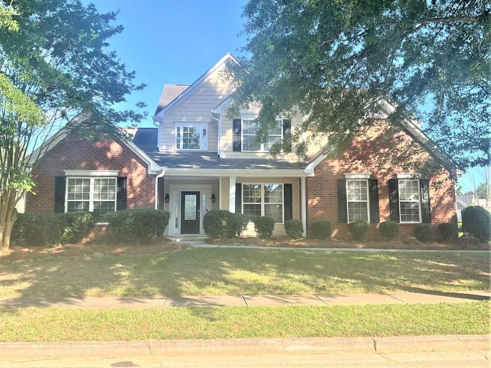 a front view of a house with a garden