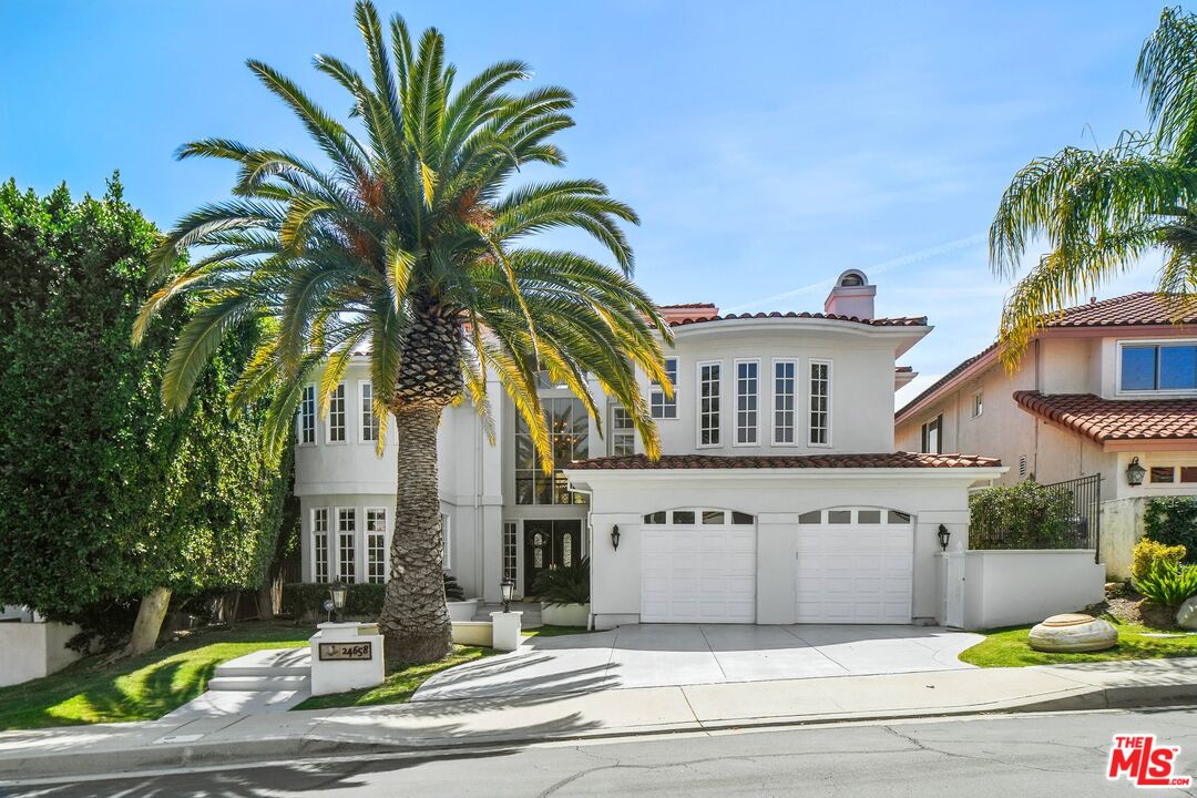 a view of a white house with palm trees