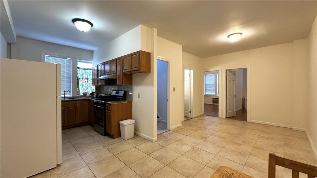 a kitchen with a refrigerator and a stove top oven