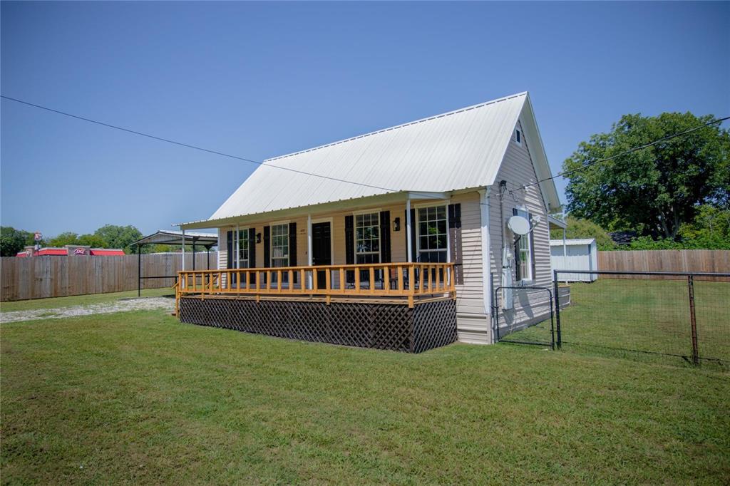 a view of house with backyard and deck