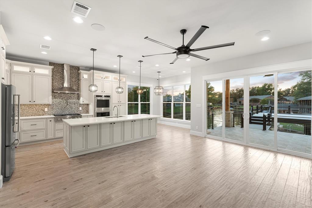 a open kitchen with stainless steel appliances granite countertop a stove and a wooden floors