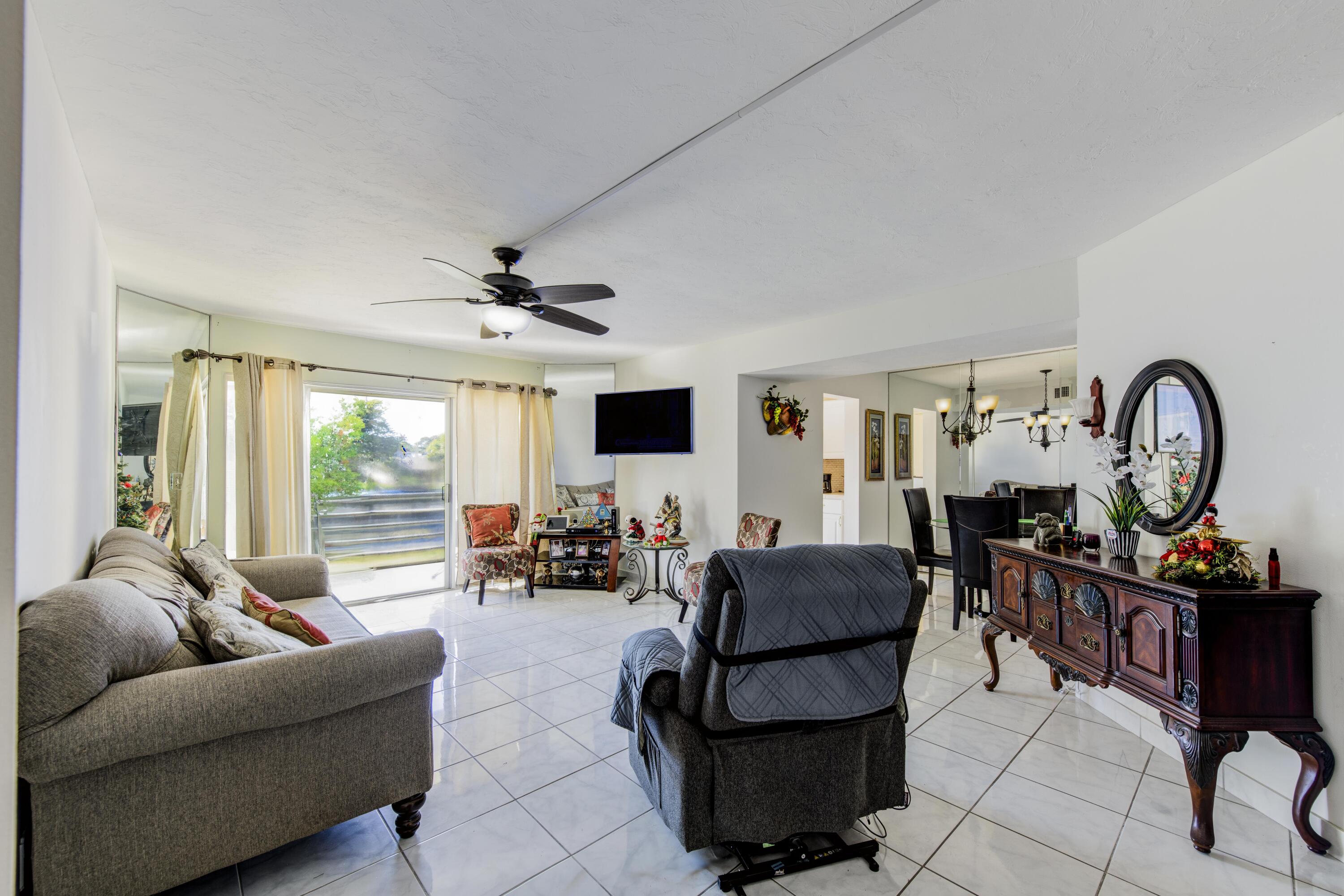 a living room with furniture a large window and a flat screen tv