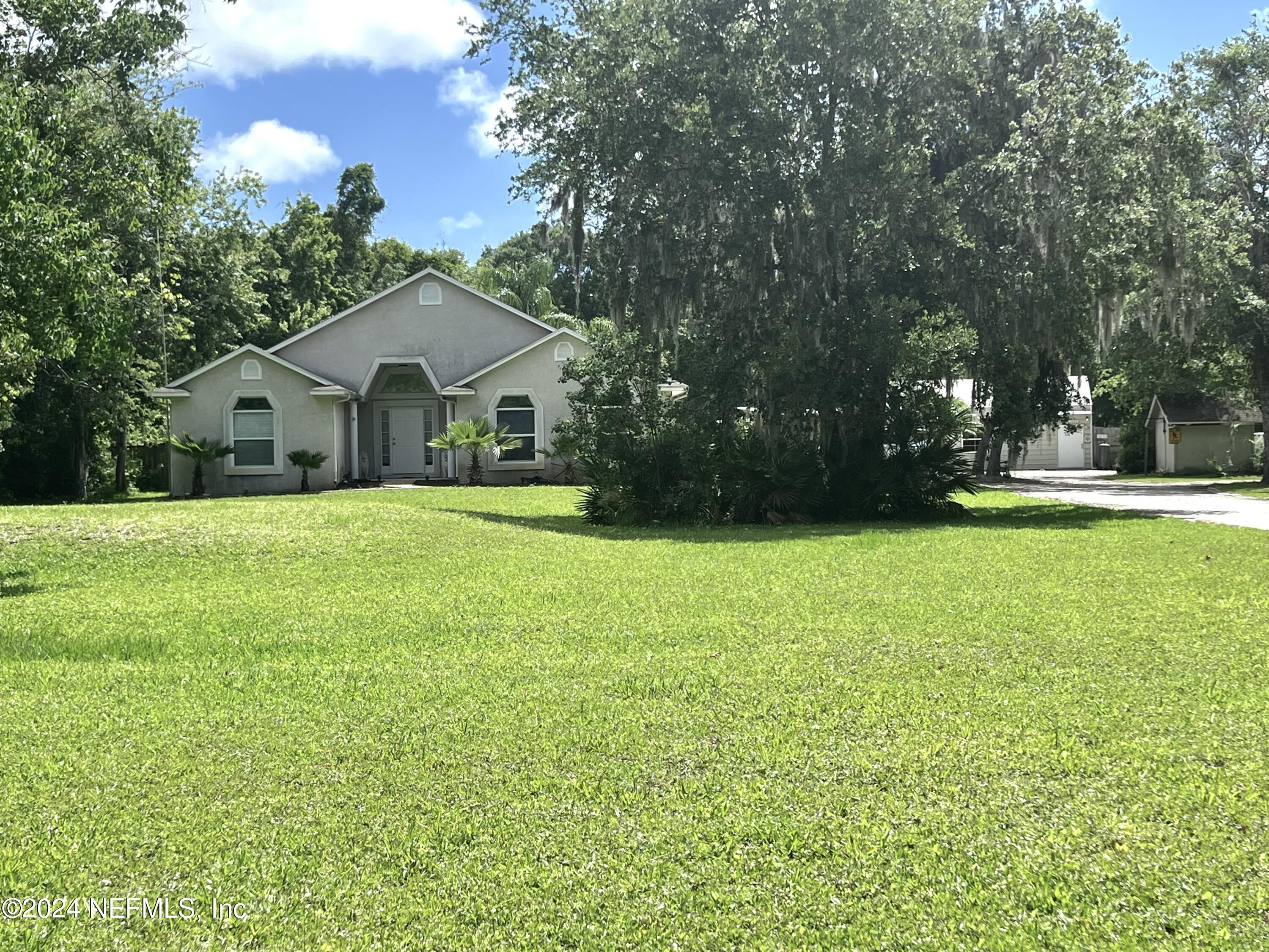 a front view of house with yard and green space