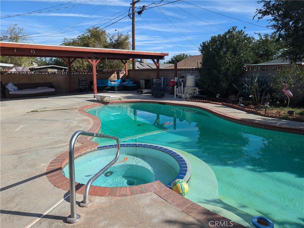 a view of a swimming pool with a patio and a yard