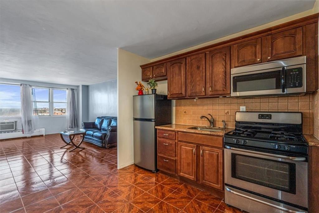 a kitchen with stainless steel appliances a stove a sink cabinets and a kitchen island