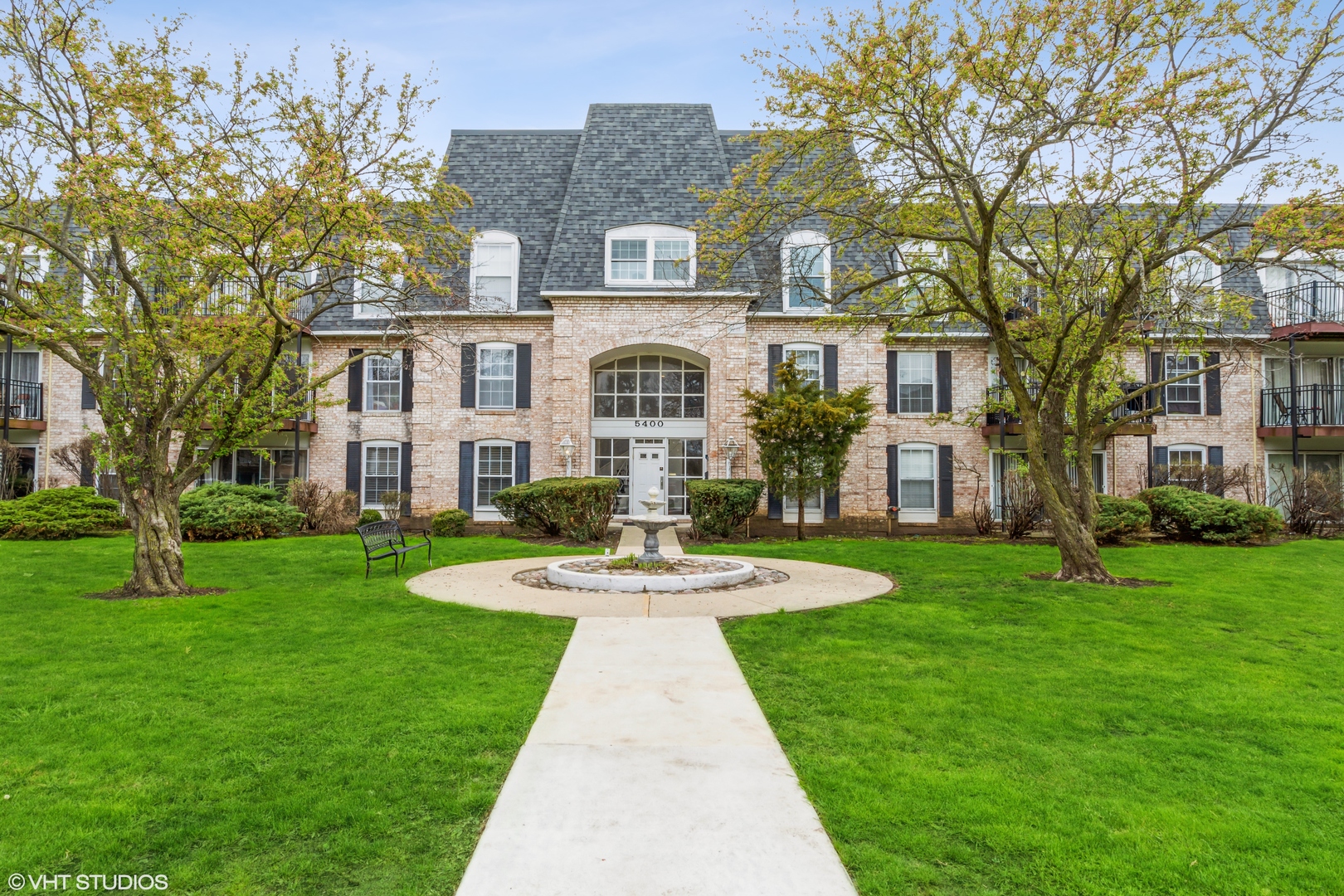 a front view of a house with yard and green space