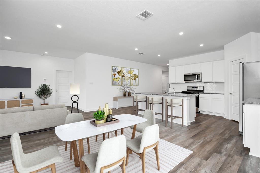 a view of kitchen with refrigerator stove dining table and chairs