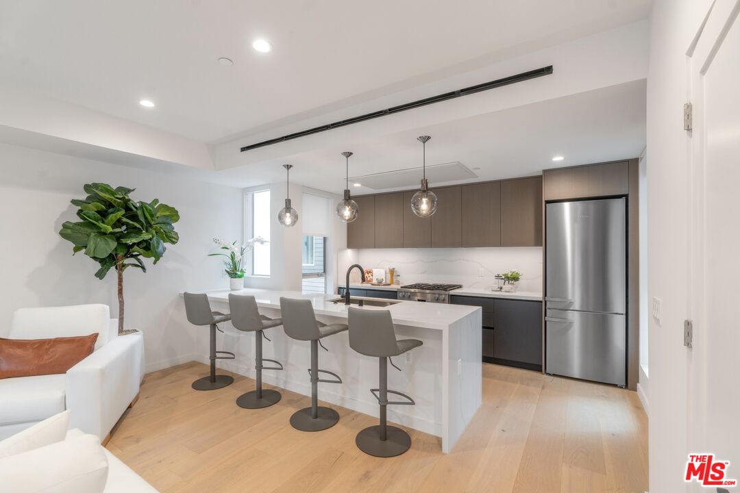 a kitchen with stainless steel appliances kitchen island granite countertop a table and chairs in it