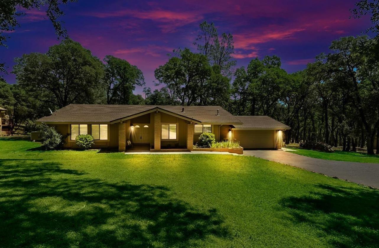 a front view of a house with yard and green space