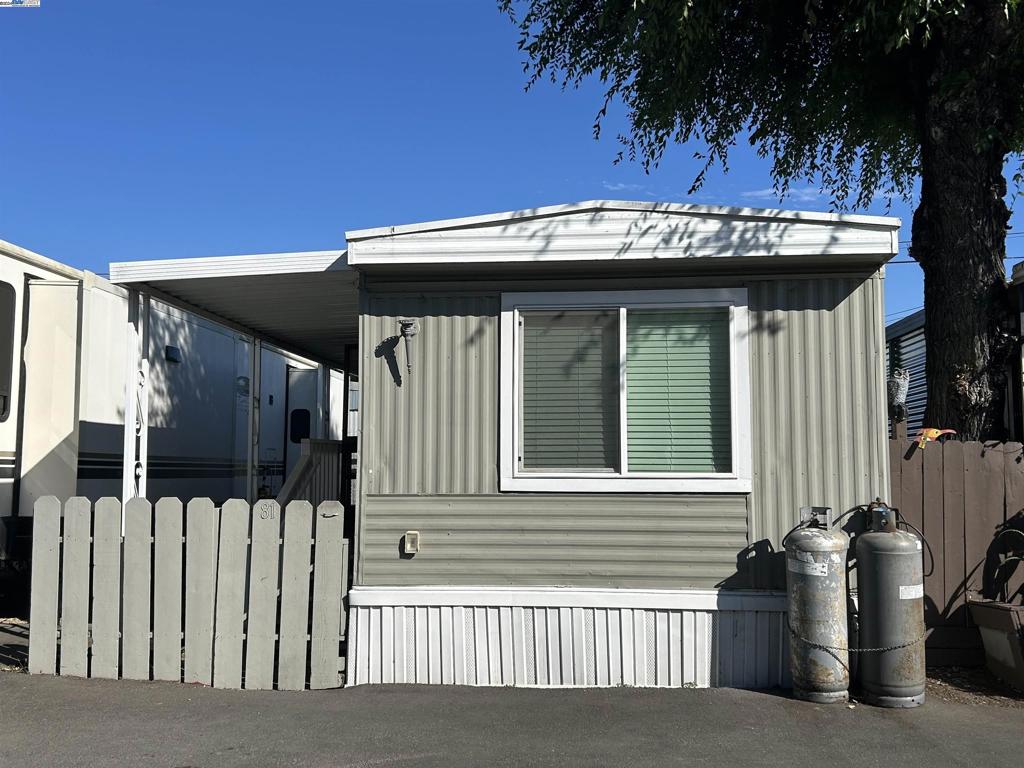 a view of a house with a small yard and wooden fence