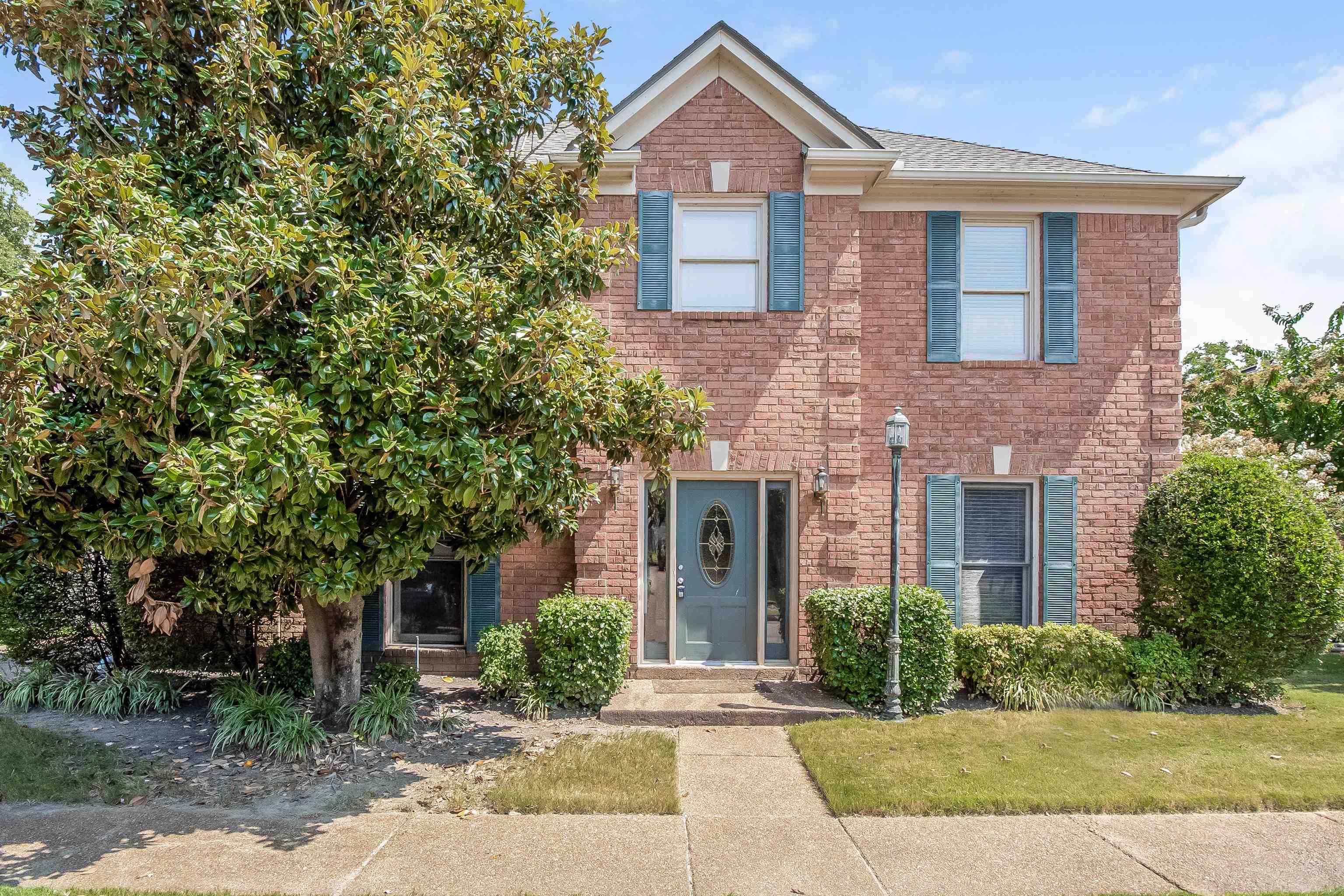 front view of a brick house with a yard