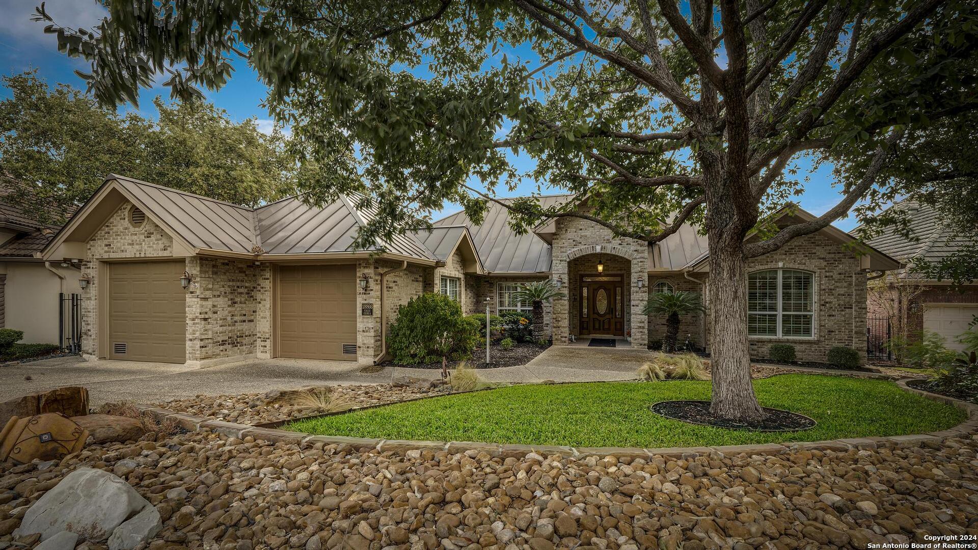 a front view of a house with a yard and trees