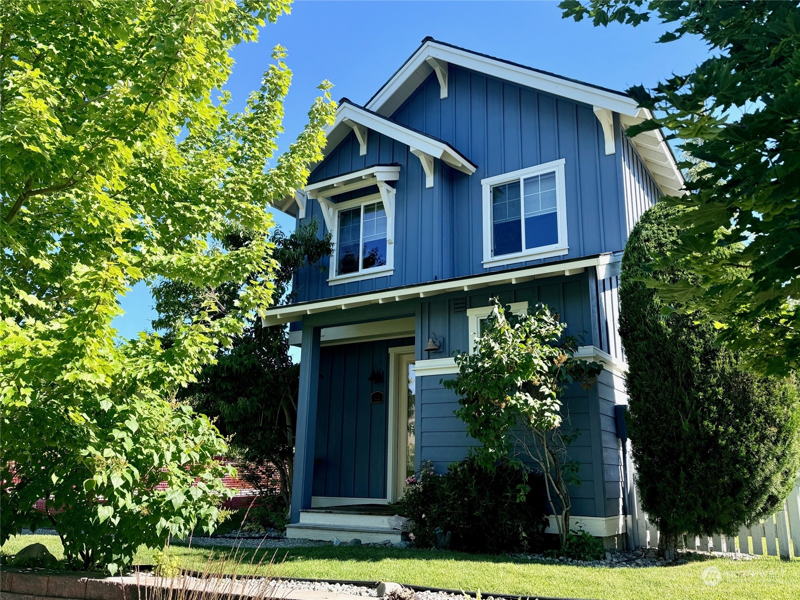 a yellow house with flower garden in front of it