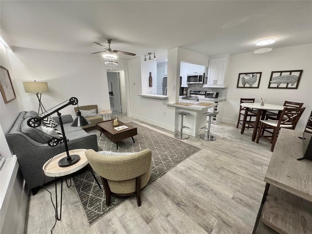 a living room with furniture and kitchen area