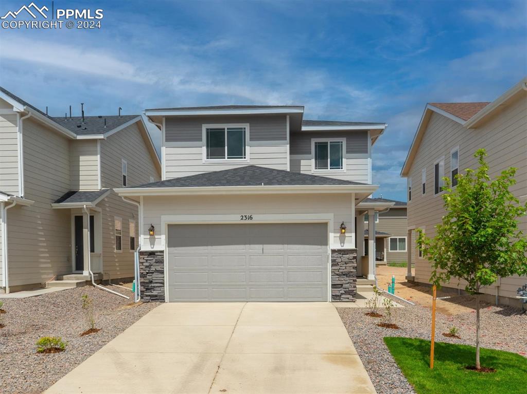 a front view of a house with a garage and a yard