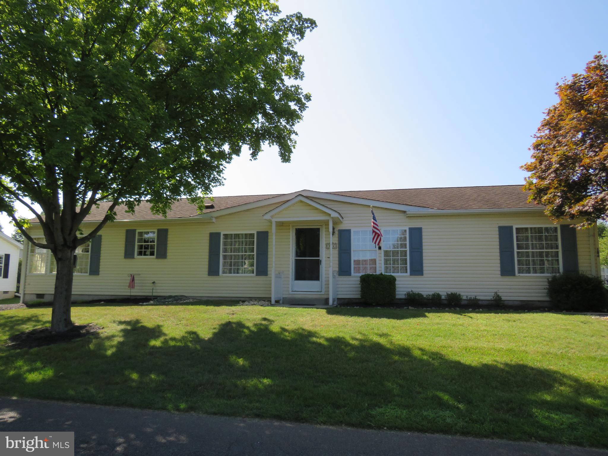 a front view of house with yard and trees in the background