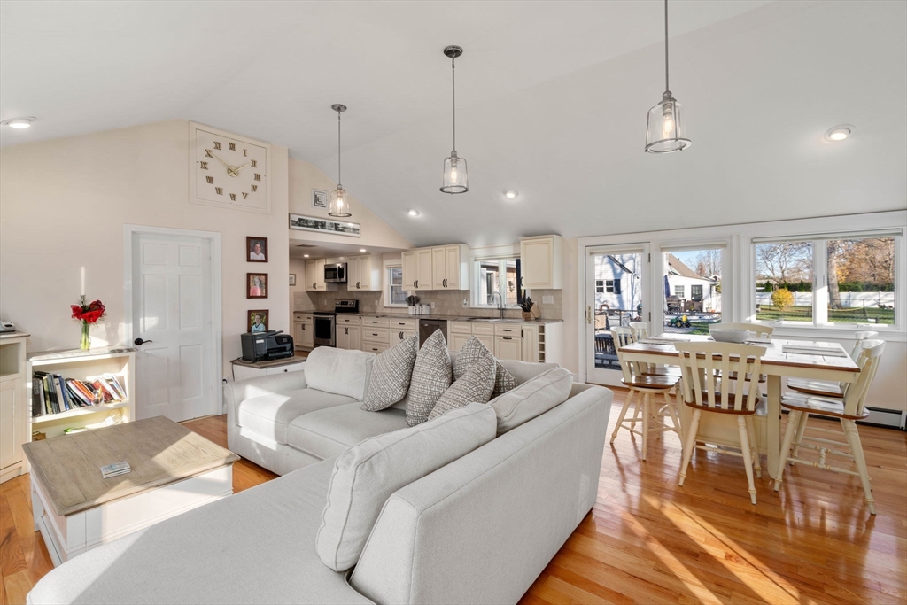 a living room with furniture kitchen view and a chandelier