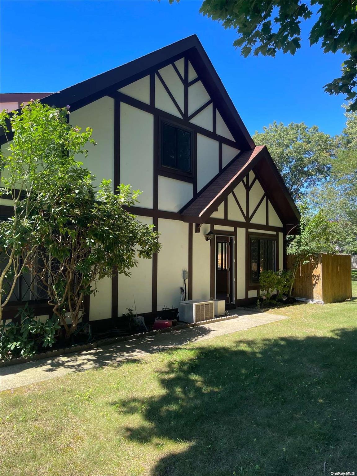 a view of a house with a big yard and large trees