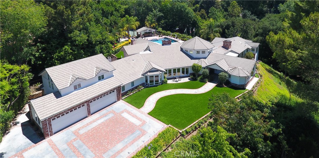 an aerial view of a house with swimming pool and outdoor seating