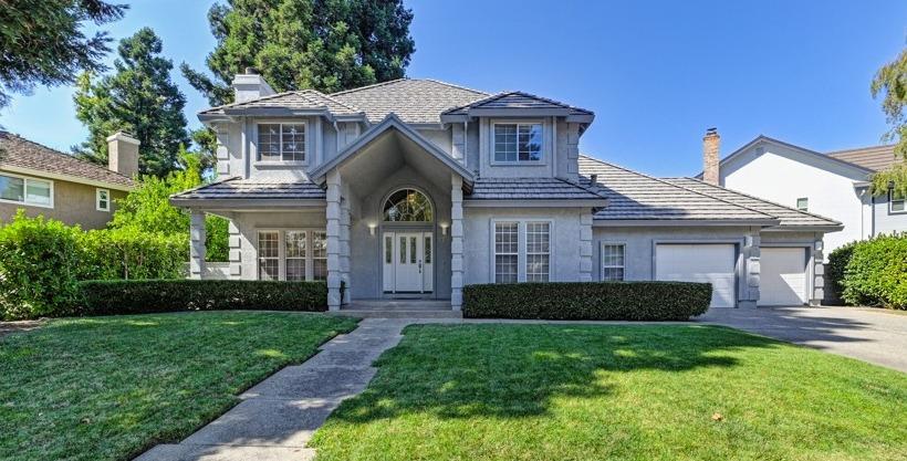 a front view of a house with a garden