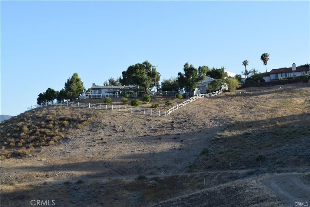 a view of a dry yard with wooden fence