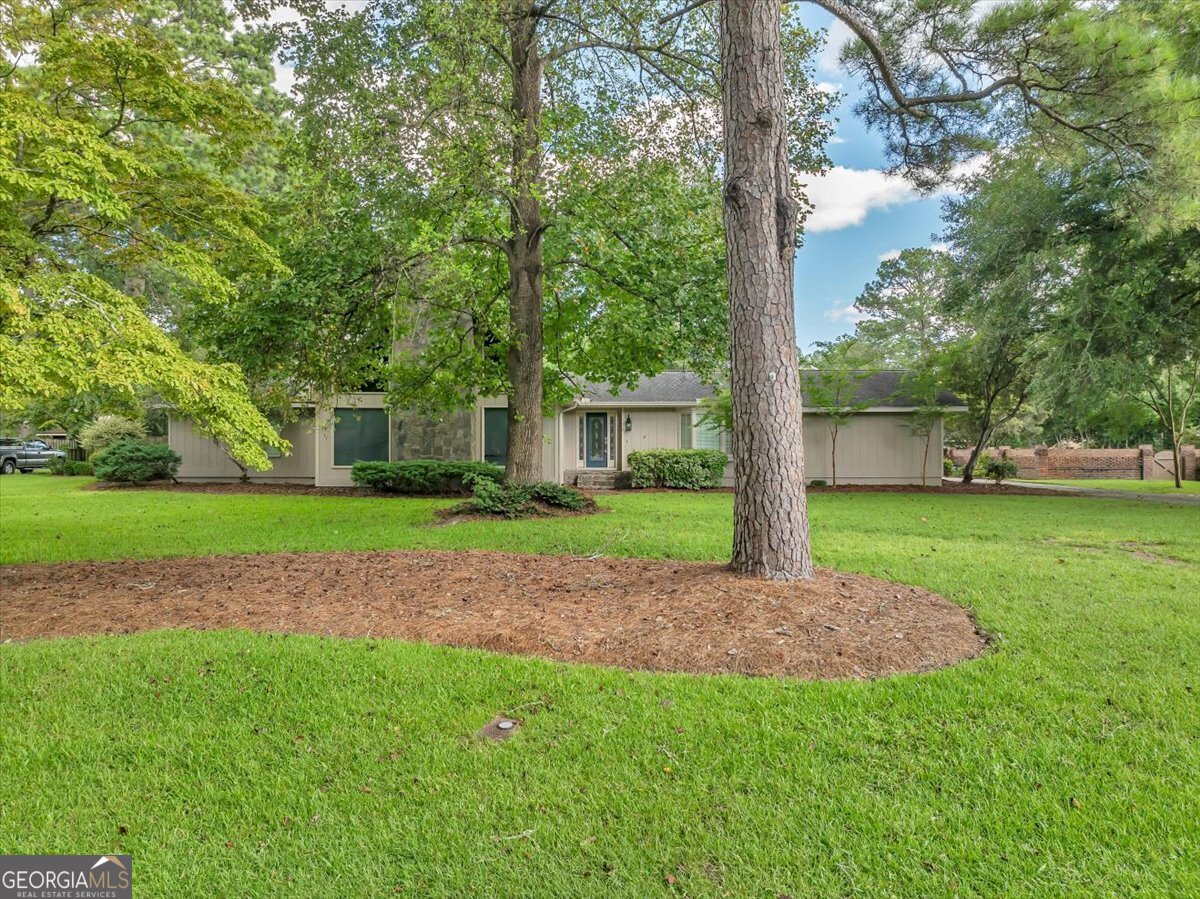 a house with green field in front of it