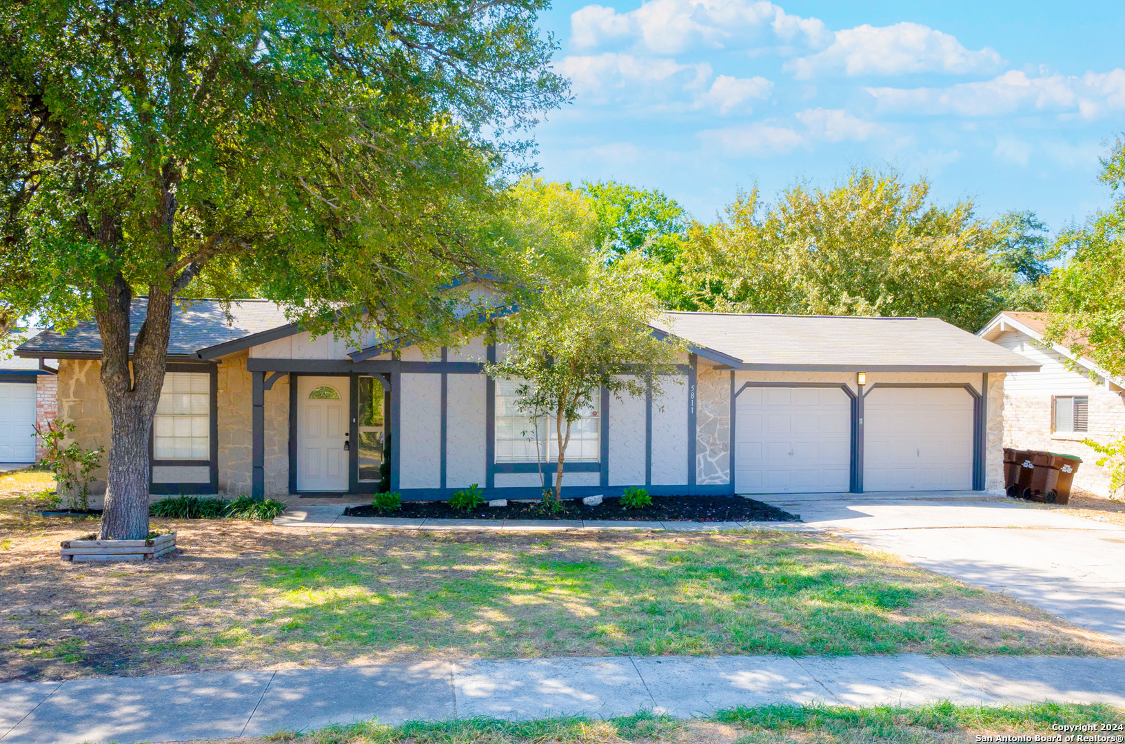 a front view of house with yard and trees