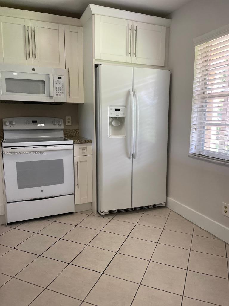 a kitchen with a white cabinets and white appliances