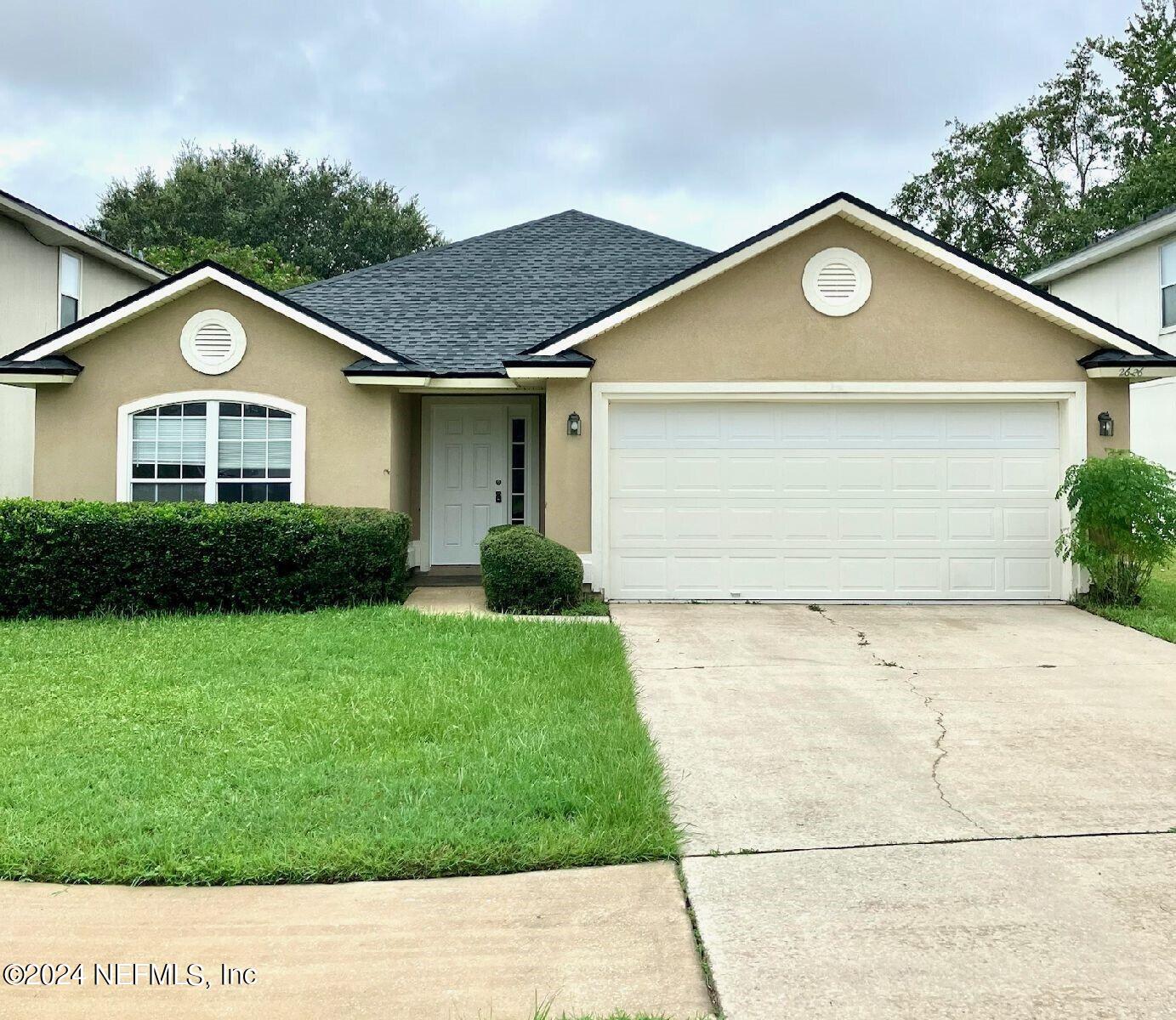 a front view of a house with a yard and garage