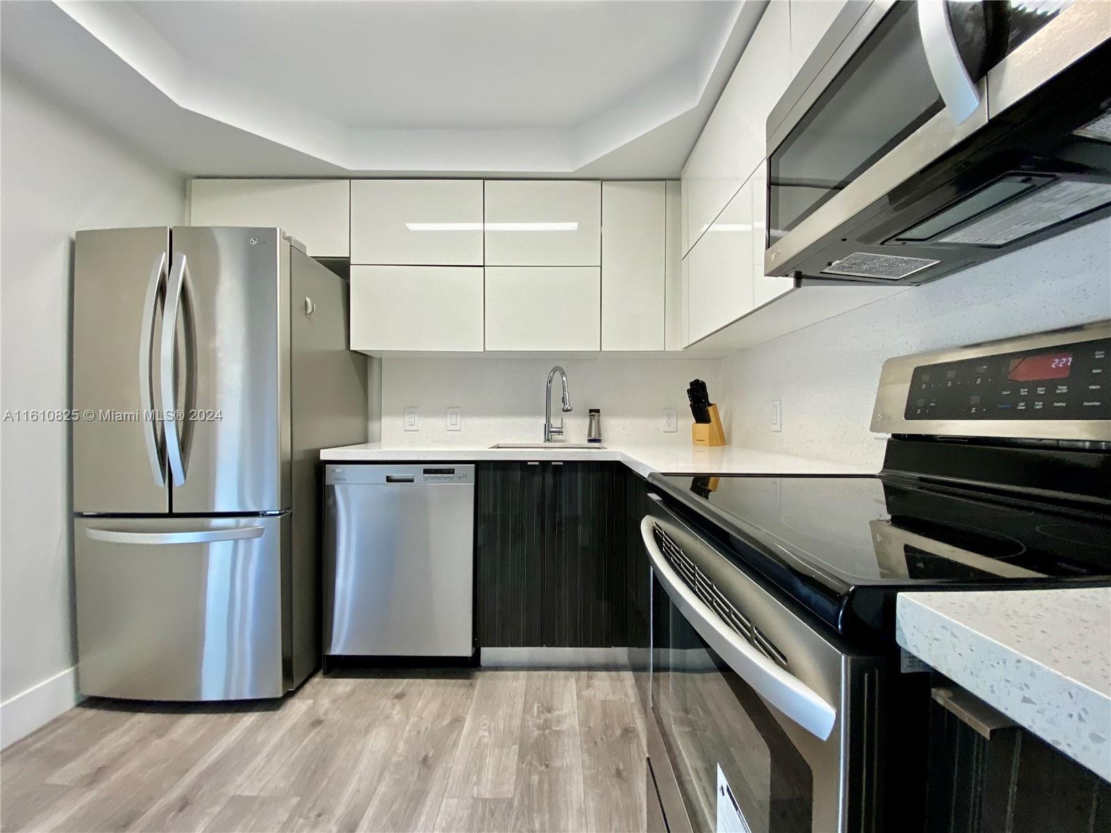 a kitchen with a refrigerator sink and cabinets