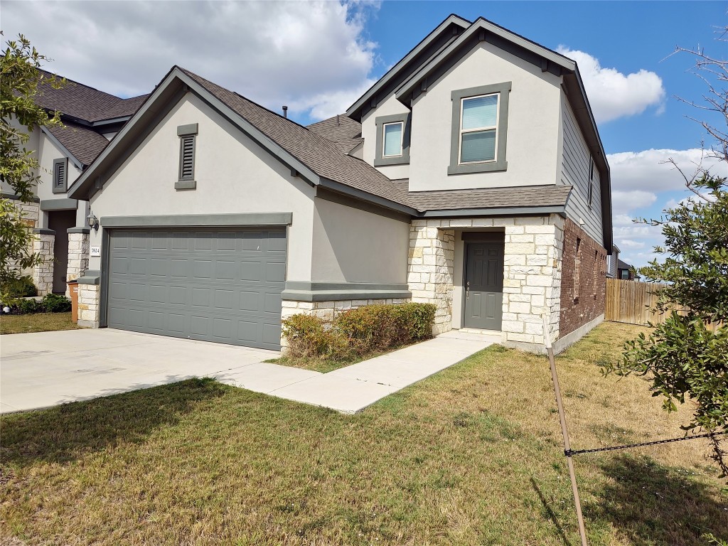 a front view of a house with a yard and garage