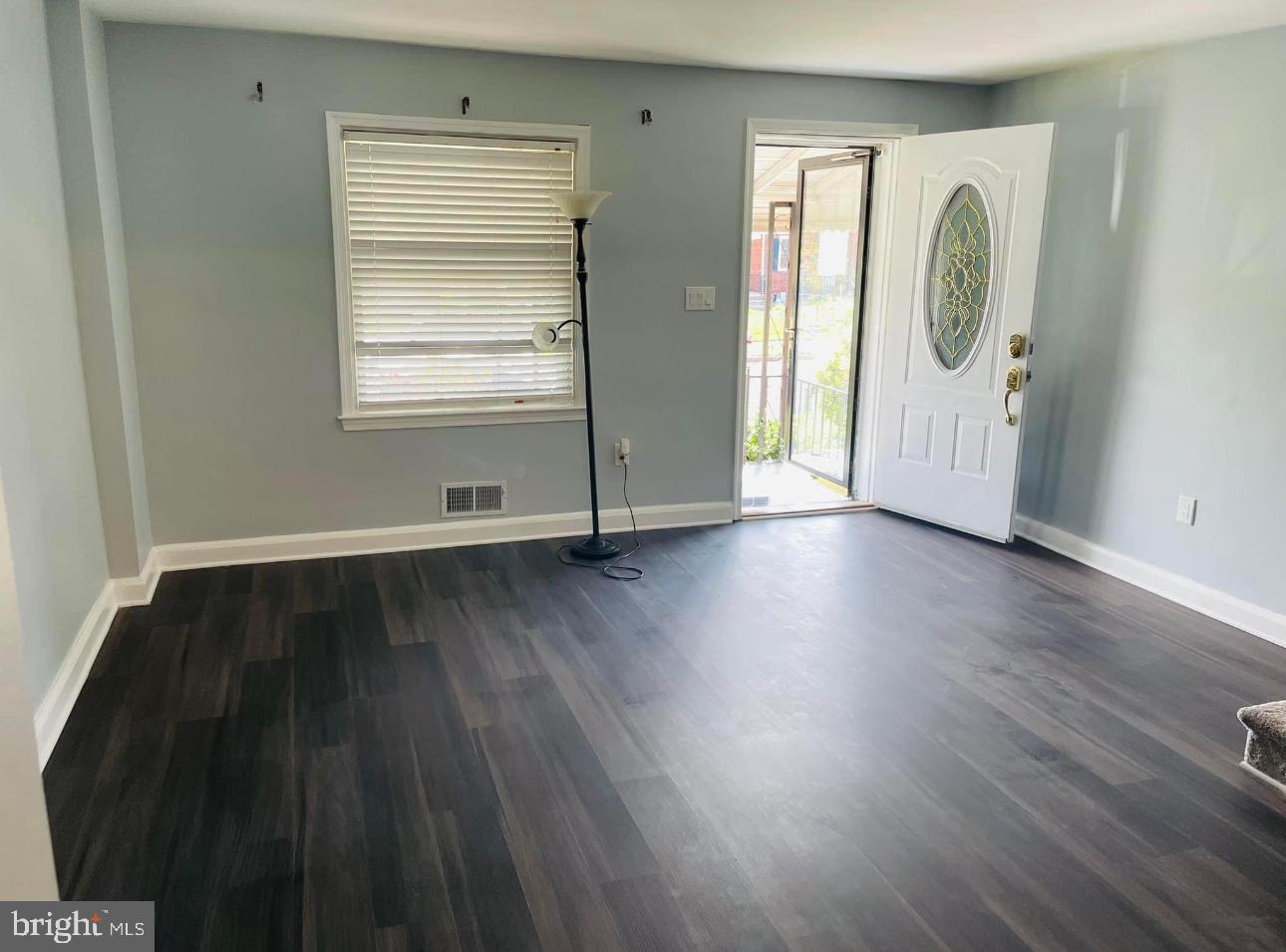 a view of a room with wooden floor and window