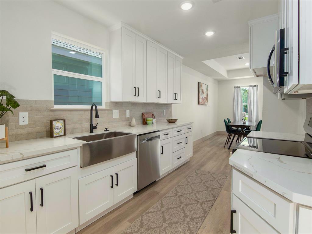 a kitchen with cabinets appliances and a sink