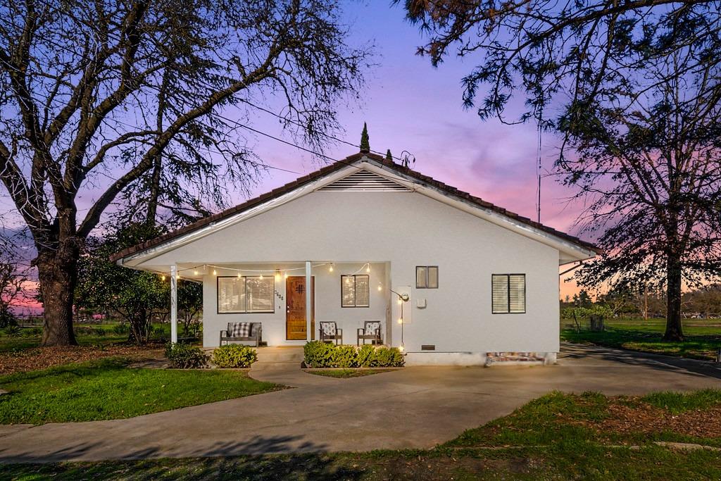 a view of a house with a yard and tree s