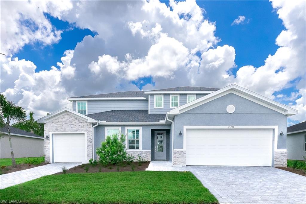 View of front of property with a garage and a front lawn