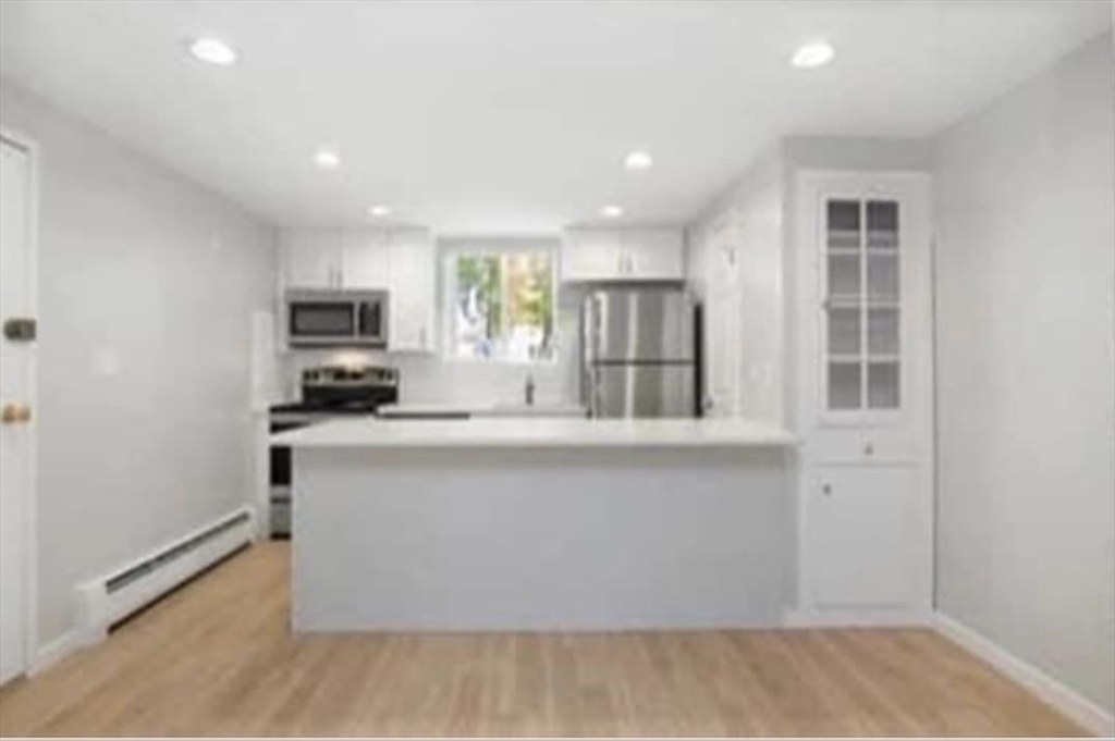 a kitchen with stainless steel appliances a microwave a sink and cabinets