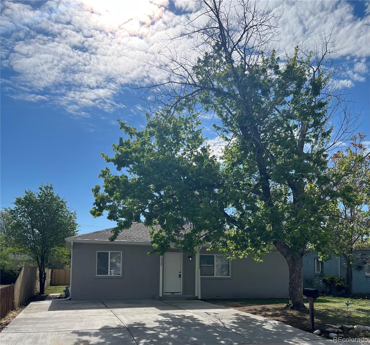 a front view of a house with a tree