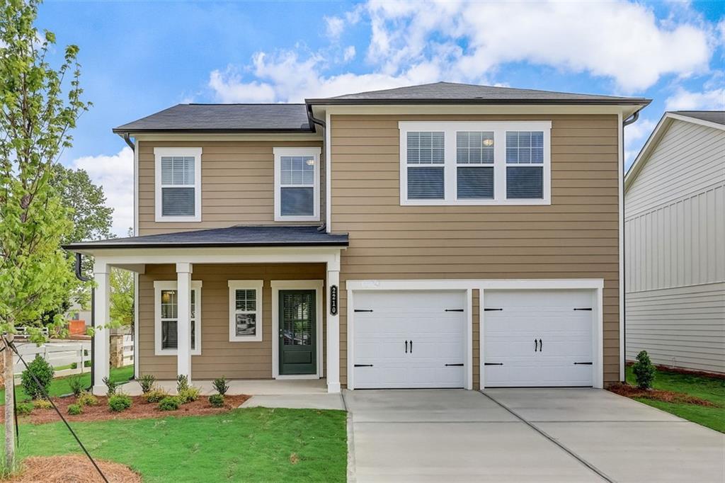 a front view of a house with a yard and garage