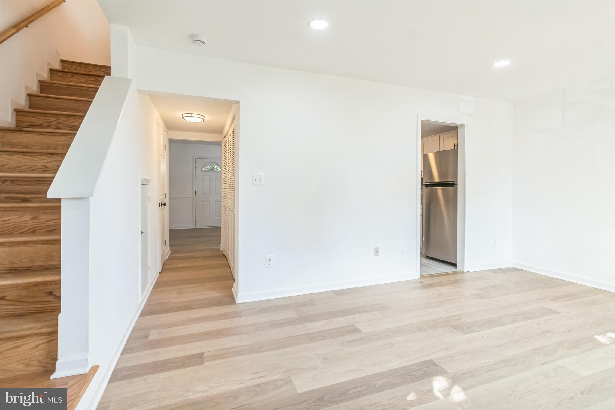 a view of a hallway with wooden floor and entryway